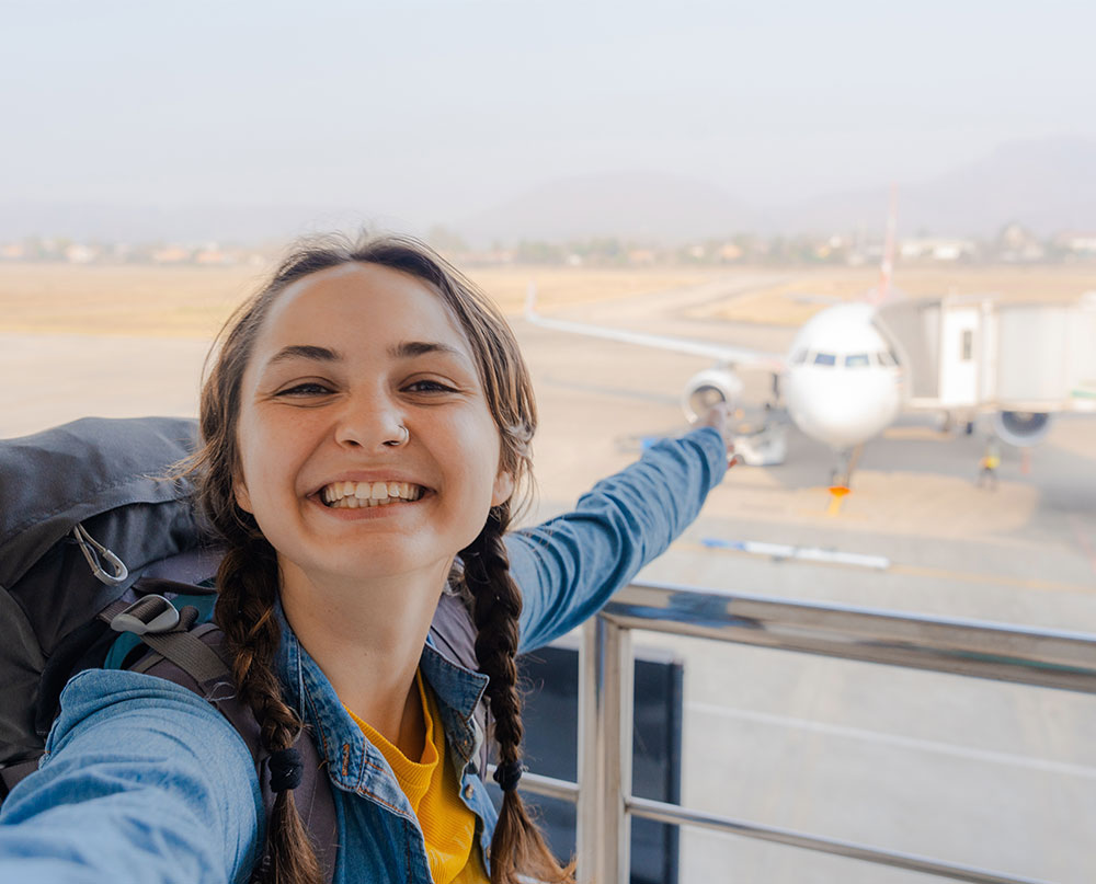 traveler taking a selfie with airplane